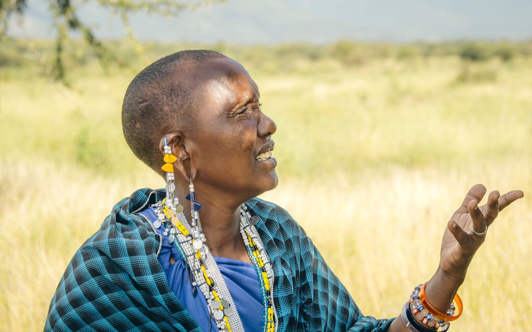 A woman in a green shuka under an open sky