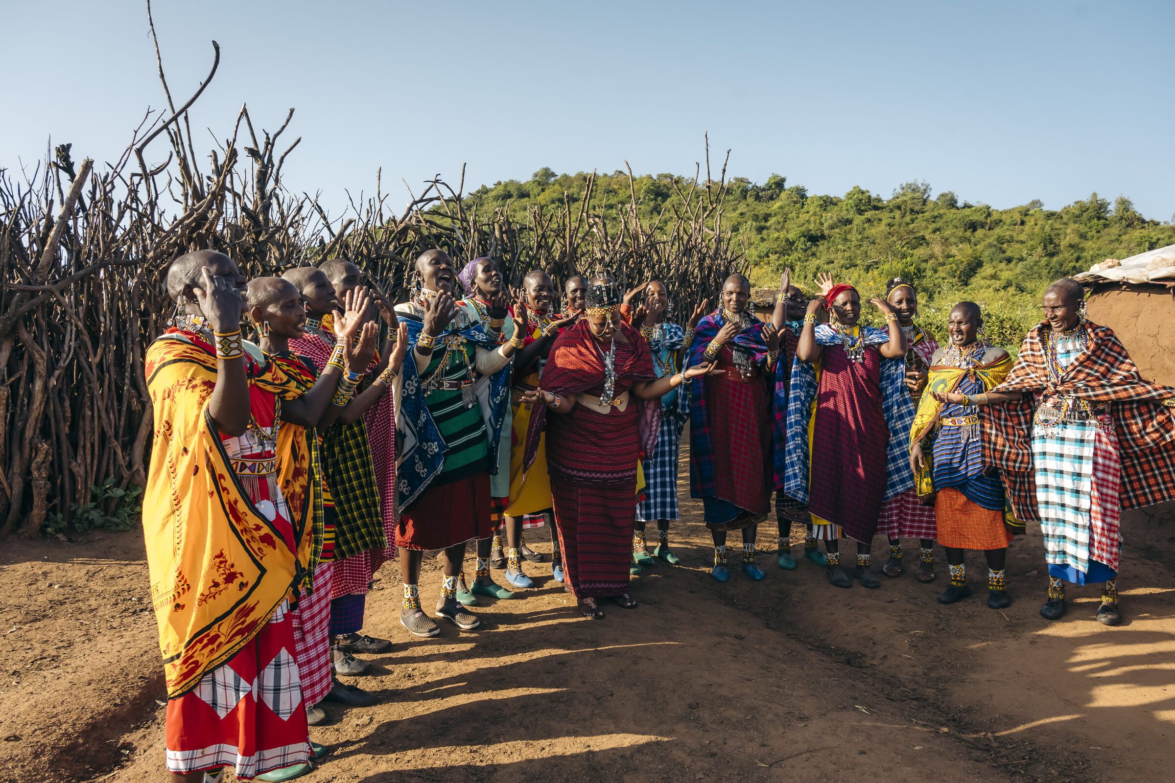 Women gathered in a line inside a boma